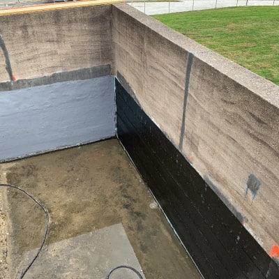 two conjoined concrete walls partially wrapped in HydraWrap for protection