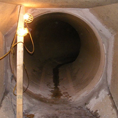 cement being applied to a joint to smooth out the transition between different pipes