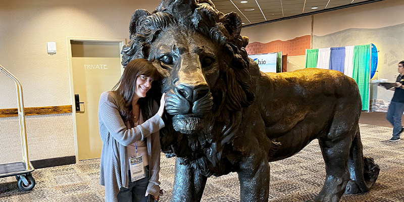 Jennifer standing next to a large metal lion statute