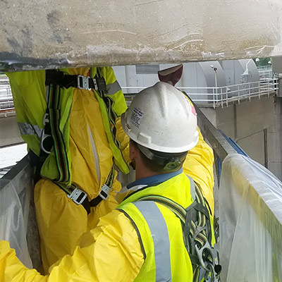 filed technician applying epoxy to the underside of a bridge