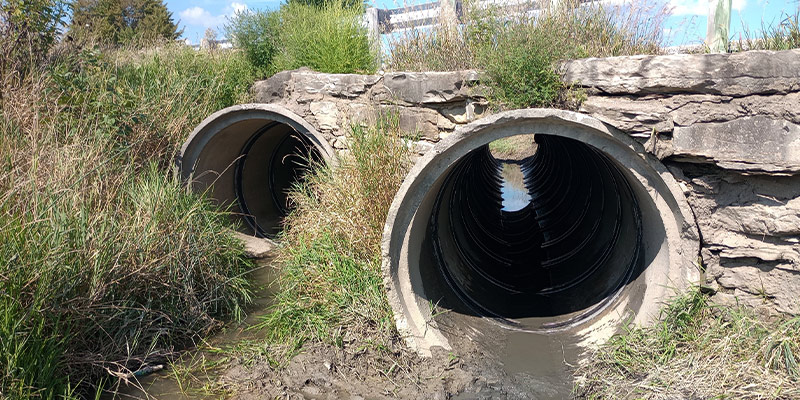 the entrance to twin culverts that run below a roadway. HydraTite installed inside the culverts to protect the joints.