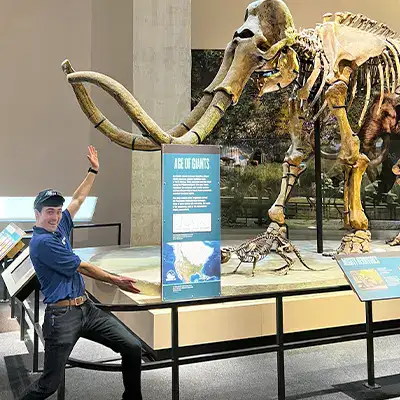 Guy standing near a mammoth skeleton