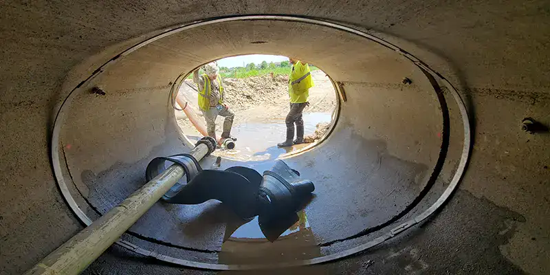 Joint with an active leak in a green PVC pipe