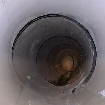 Two technicians installing HydraTite in a round pipe