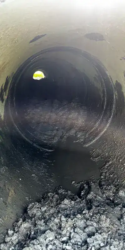 Joint with an active leak in a green PVC pipe