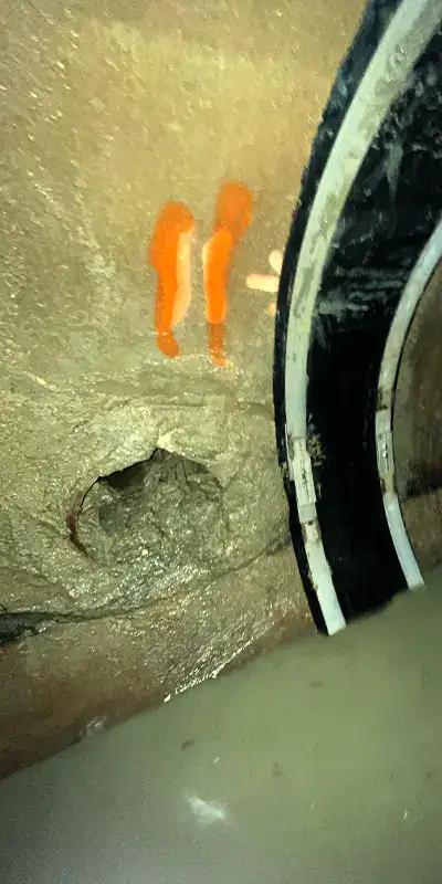 Joint with an active leak in a green PVC pipe