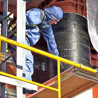 A field technician smoothing the carbon fiber fabric out to ensure proper installation