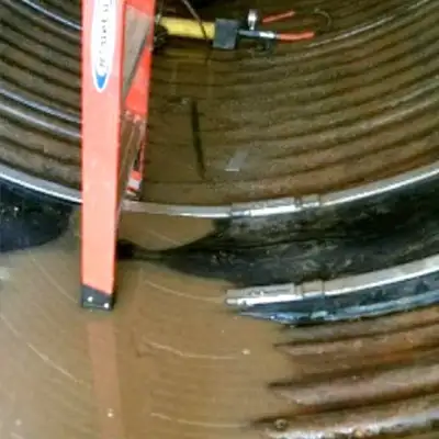 A technician sitting in a pipe with HydraTite seals installed over the pipe's joints