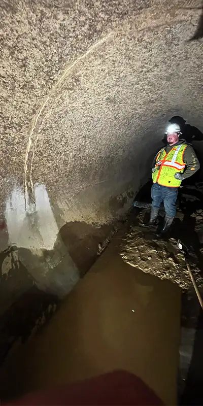 Two technicians installing HydraTite in a round pipe