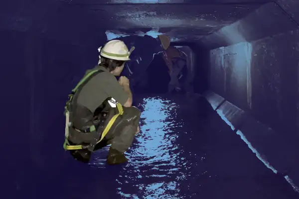 Technician sitting in a box culvert