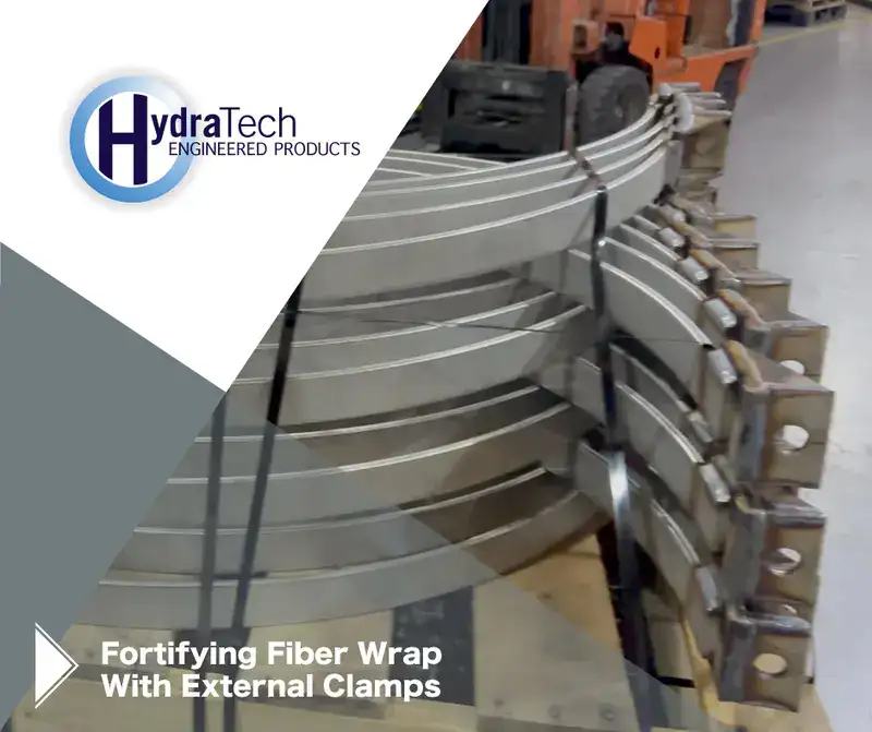 Fortifying External Clamps3 A stack of steel on a shipping pallet, 'Fortifying Fiber Wrap With External Clamps"