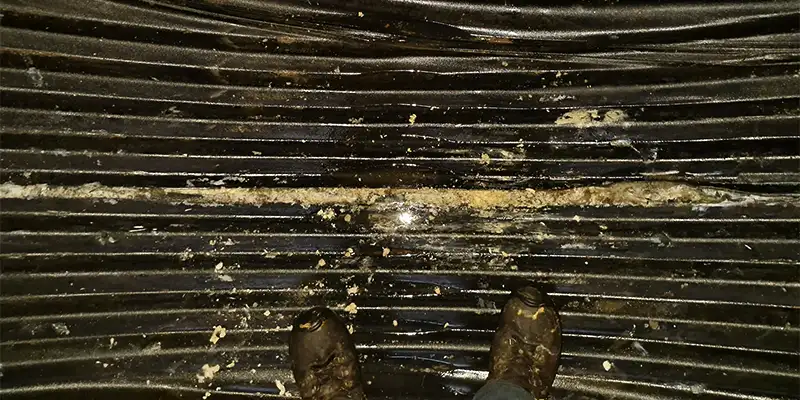 Two technicians installing HydraTite in a round pipe