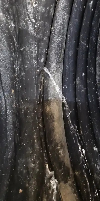 Two technicians installing HydraTite in a round pipe