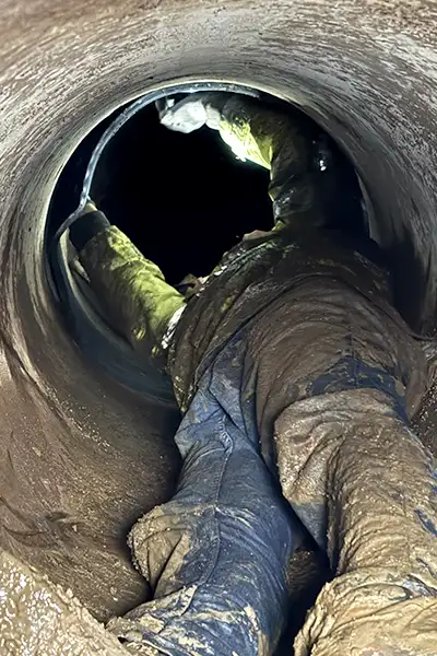 A technician in a small-diameter pipe installing HydraTite, the internal pipe joint seal, over a joint to fortify it against leaks