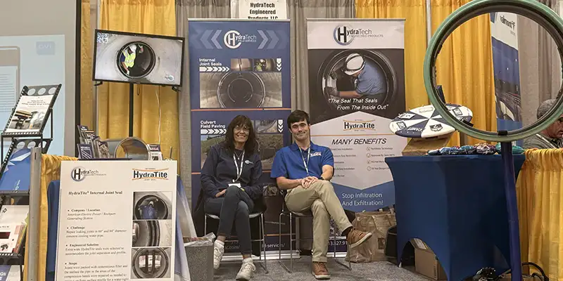 two people sitting at a trade show booth