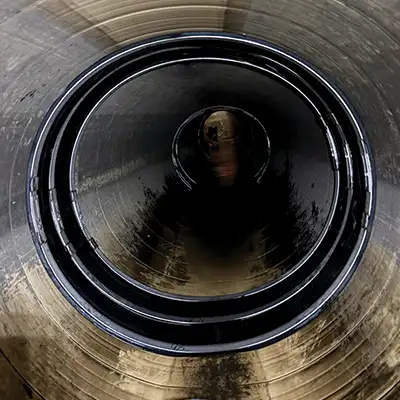 A dark pipe repaired with a HydraTite seal, installed with three retaining bands.