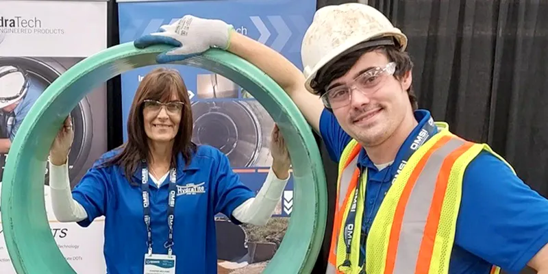 Two people standing near a demo HydraTite seal