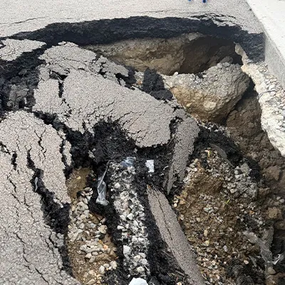 A portion of pavement that has collapsed into a sinkhole